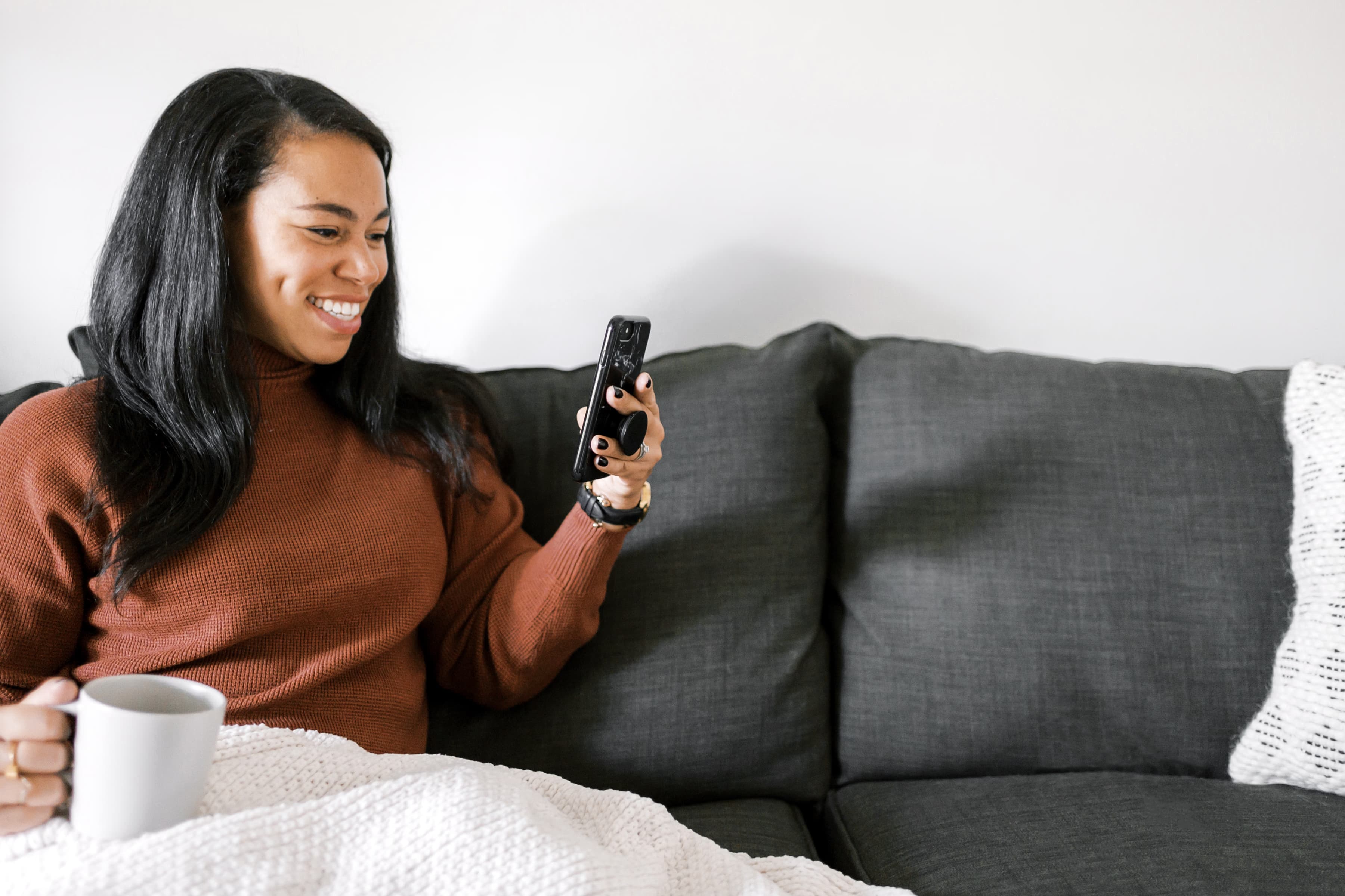 Woman relaxing on a couch while looking at her phone